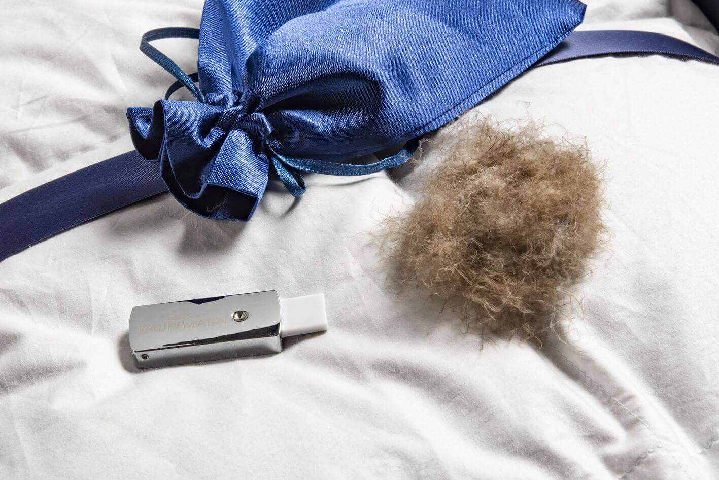 Luxurious Eiderdaunendecke Exclusive showcasing sustainable eiderdown with elegant blue packaging on a plush bed.